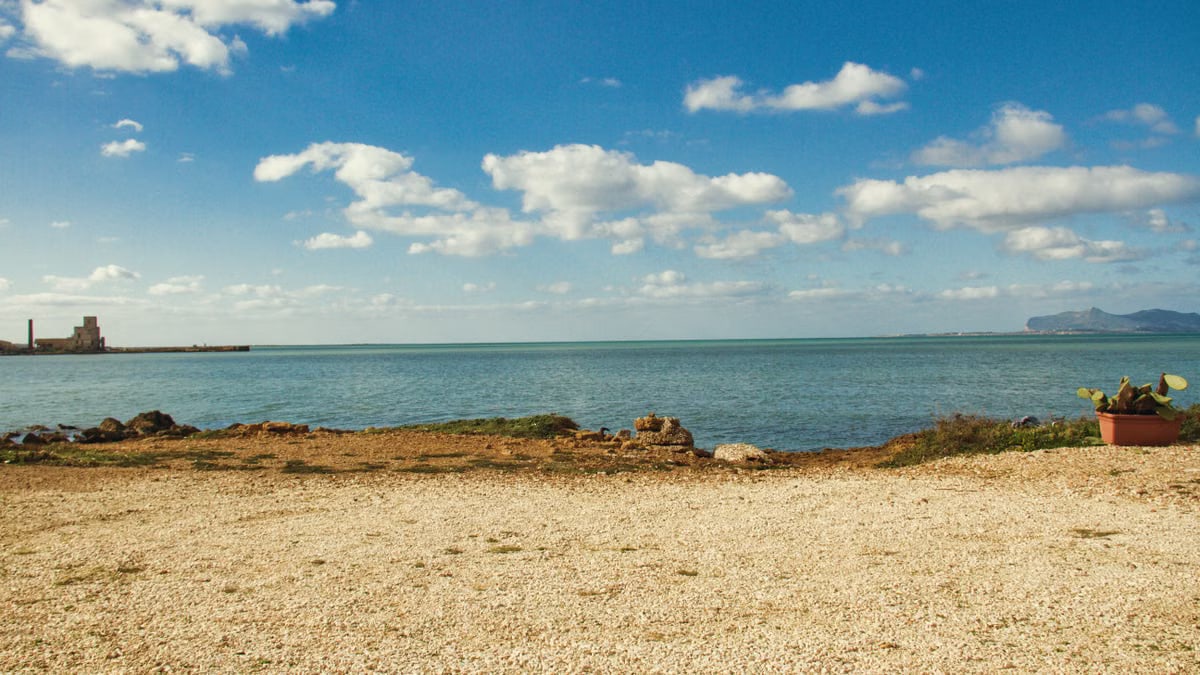 Tranquil view of the coastline in Trapani, Sicily with clear blue sky and sea.